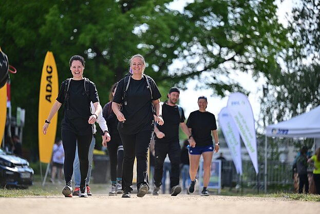 Teilnehmerinnen im Ziel Zwei Frauen bei Wanderung mit Rucksack auf dem Weg ins Ziel