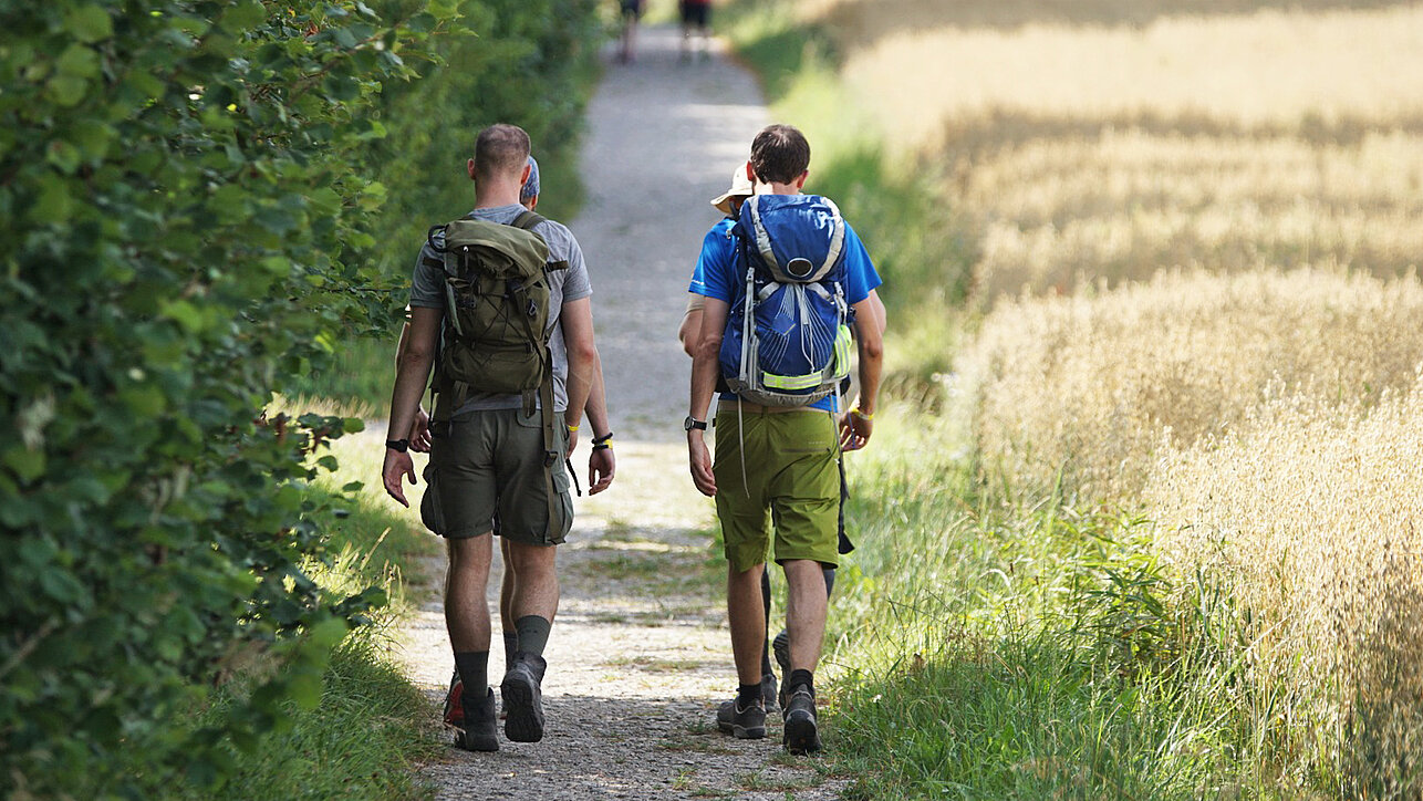 Zwei Wanderer mit Rucksack und Wanderschuhen auf Wanderweg in der Natur ©SCC