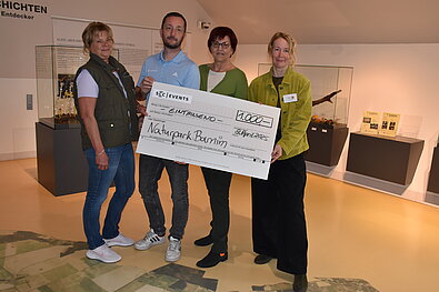 HIKING HERO: Beate Kerkhofer (1. Vorsitzende Schönower-Heide-Verein e. V.), Robert Müller (SCC EVENTS), Petra Bierwirth (Vorsitzende Förderverein Naturpark Barnim e. V.) und Dr. Aija Torkler ( Naturparkleiterin Naturpark Barnim) bei der Scheckübergabe (v. l. n. r.). @ SCC EVENTS / Naturpark Barnim